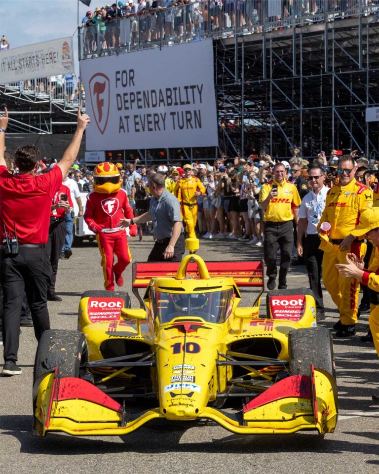 The winning No. 10 car surrounded by celebrating crew with the Firestone mascot